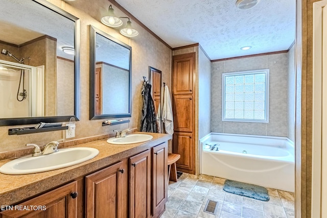 full bathroom featuring ornamental molding, a garden tub, a sink, and a textured ceiling