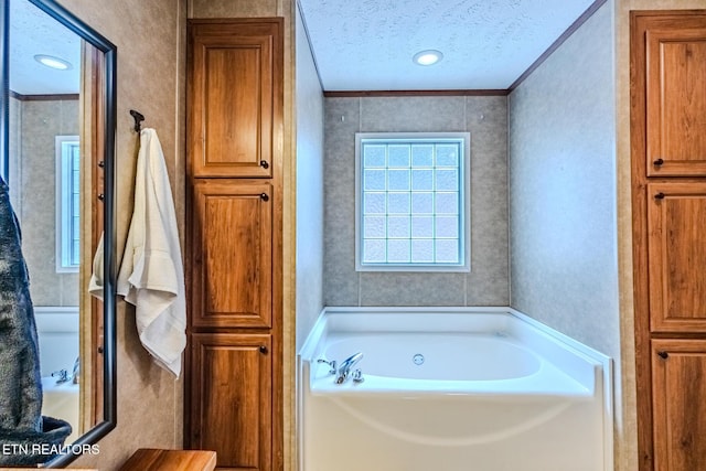 full bath with a garden tub, crown molding, and a textured ceiling