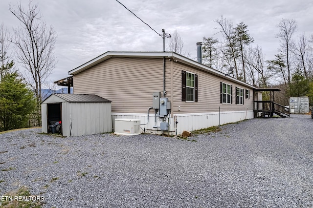 view of side of home featuring an outbuilding and a storage unit