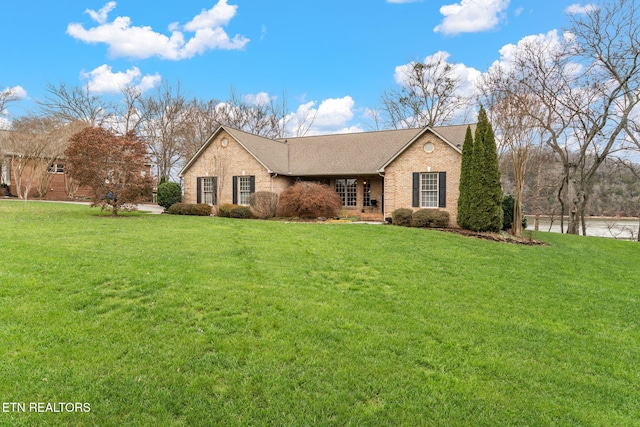 view of front facade featuring a front lawn, brick siding, and a shingled roof