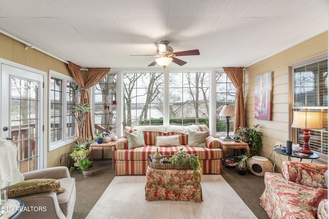 sunroom / solarium featuring a ceiling fan and a healthy amount of sunlight