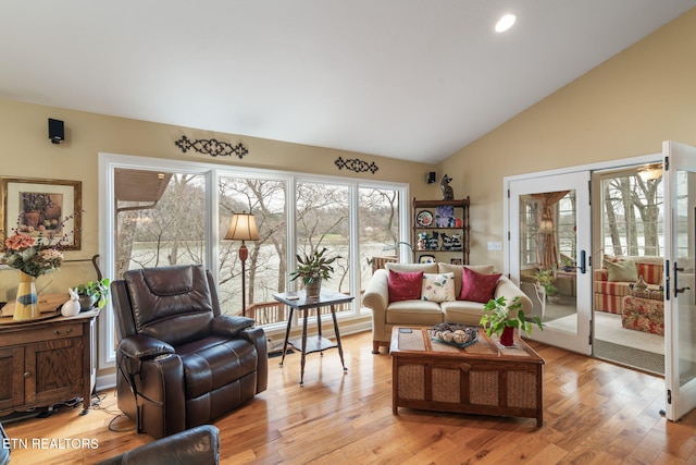 living area with recessed lighting, french doors, high vaulted ceiling, and light wood-style floors