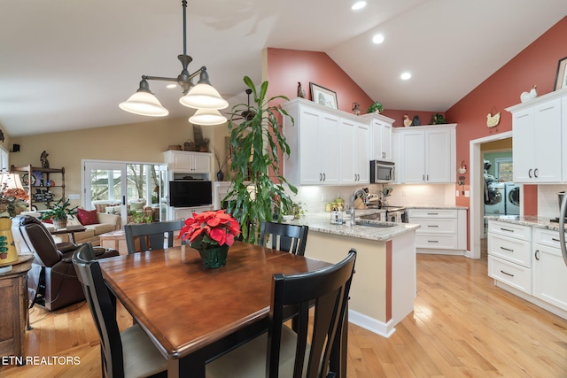 dining area with recessed lighting, light wood-style floors, separate washer and dryer, and vaulted ceiling