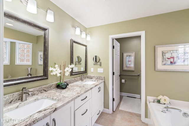 bathroom with double vanity, tile patterned floors, baseboards, and a sink