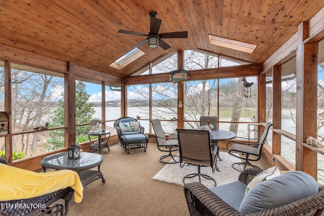 sunroom featuring lofted ceiling with skylight, wooden ceiling, a ceiling fan, and a water view