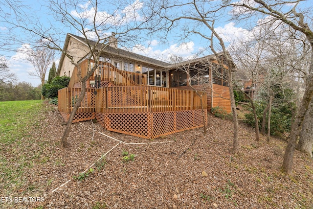 rear view of property with a wooden deck and a chimney