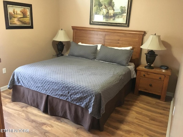 bedroom with wood finished floors and baseboards