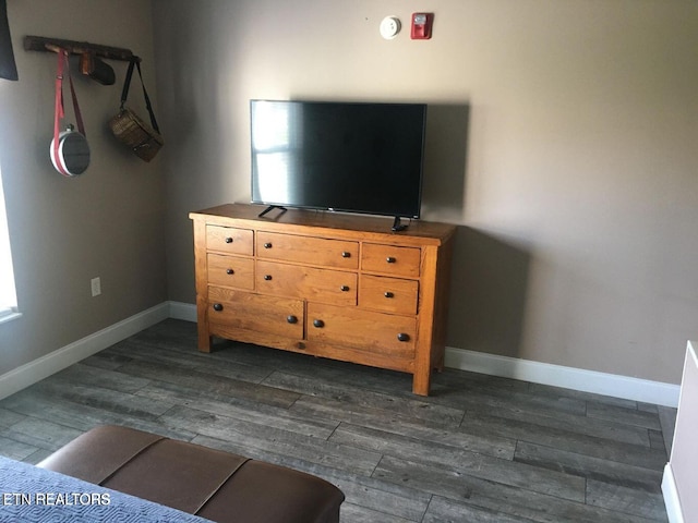 unfurnished bedroom with dark wood-style floors, multiple windows, and baseboards