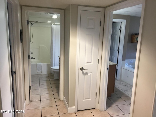 bathroom with toilet, tile patterned flooring, and shower / washtub combination