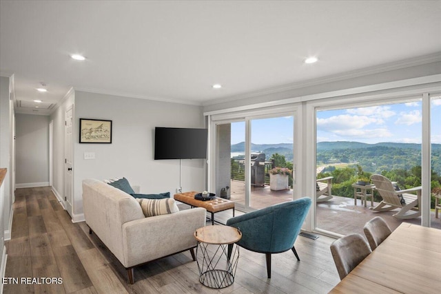 living room with ornamental molding, plenty of natural light, and wood finished floors