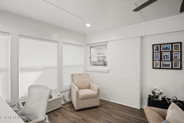 office with brick wall, dark wood finished floors, and a wealth of natural light