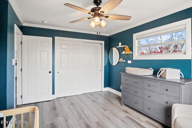 bedroom featuring baseboards, light wood-style flooring, ceiling fan, ornamental molding, and a closet