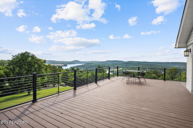 wooden deck featuring outdoor dining area and a mountain view