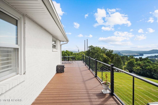 wooden terrace with a mountain view and a lawn