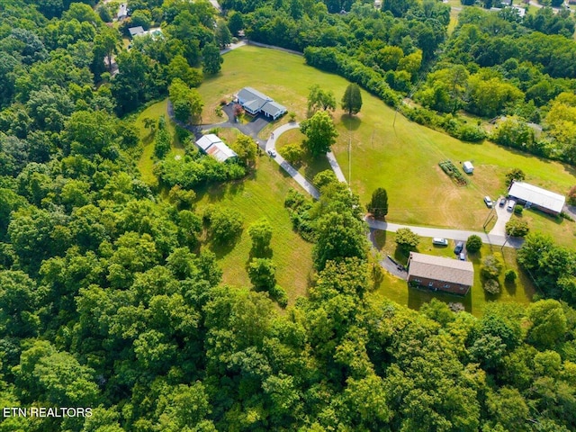 drone / aerial view featuring a view of trees and a rural view