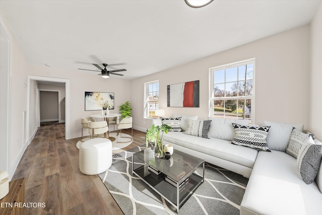 living room featuring baseboards, a ceiling fan, and wood finished floors