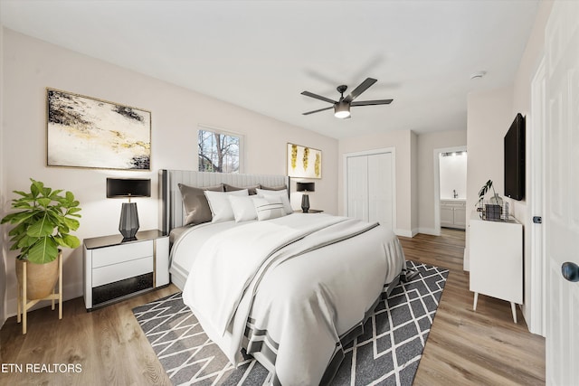 bedroom with light wood-type flooring, baseboards, a ceiling fan, and a closet