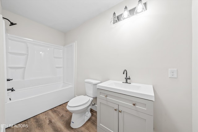 full bath with toilet, bathtub / shower combination, wood finished floors, and vanity