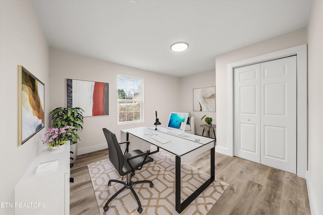 office space with light wood-type flooring and baseboards