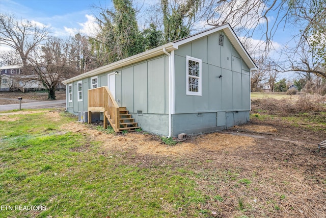 exterior space with crawl space, board and batten siding, and a front yard