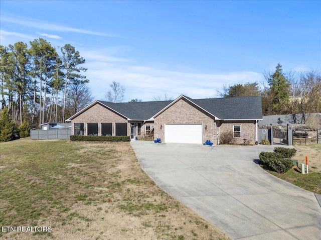 ranch-style home with a garage, brick siding, fence, concrete driveway, and a front yard