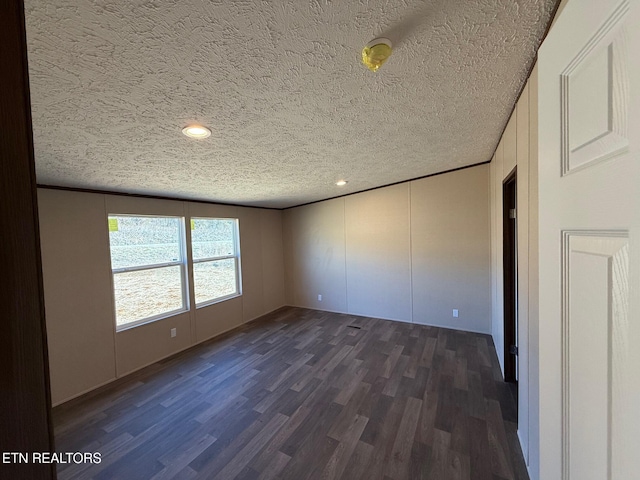 unfurnished bedroom featuring crown molding, a textured ceiling, and dark wood-type flooring