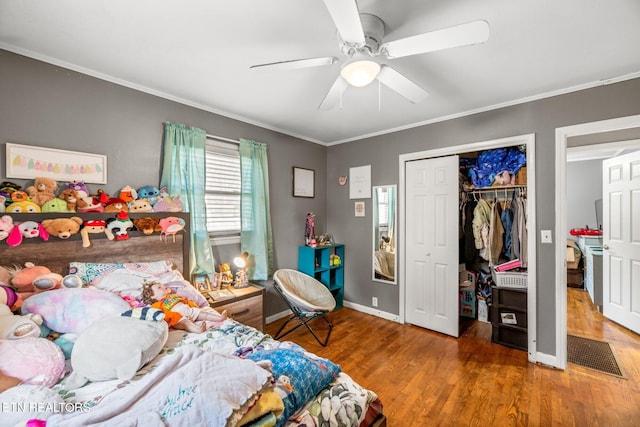 bedroom with baseboards, a ceiling fan, ornamental molding, wood finished floors, and a closet