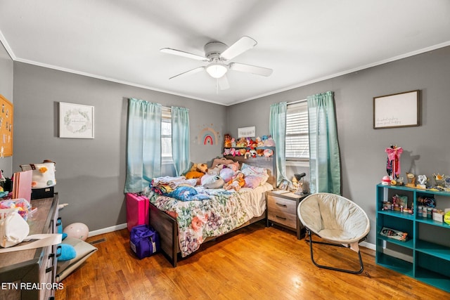 bedroom with ornamental molding, ceiling fan, baseboards, and wood finished floors