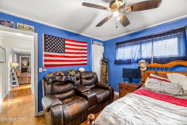 bedroom featuring crown molding, wood finished floors, a ceiling fan, and baseboards