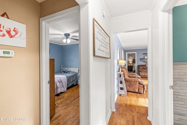 hallway with ornamental molding and wood finished floors