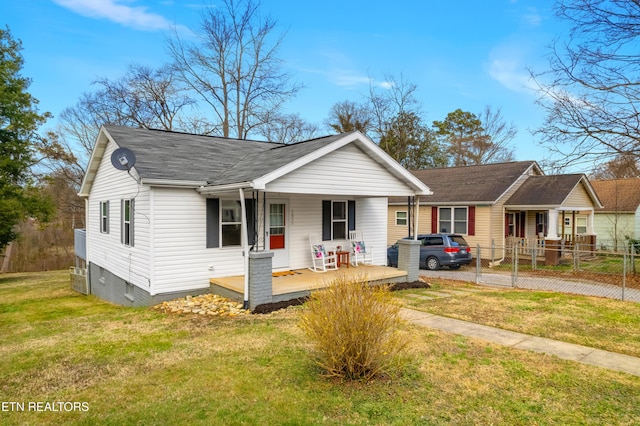 view of front of house with covered porch, a front lawn, and fence