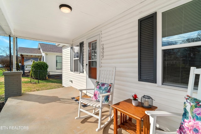 view of patio / terrace featuring covered porch and fence