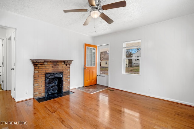 unfurnished living room with visible vents, a fireplace, a textured ceiling, and hardwood / wood-style floors