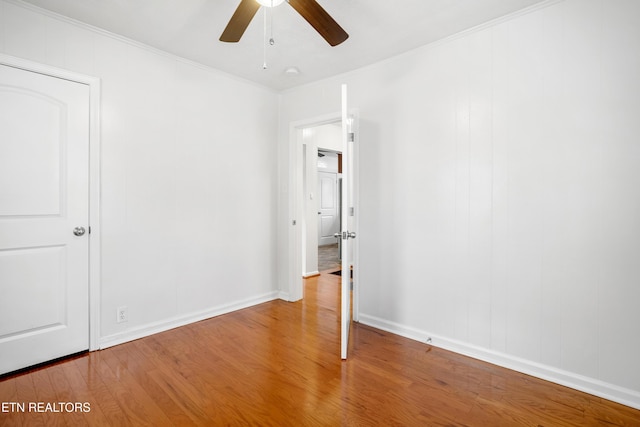 empty room featuring ceiling fan, ornamental molding, and wood finished floors