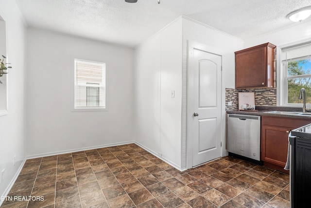 kitchen with dark countertops, decorative backsplash, stainless steel dishwasher, a sink, and a textured ceiling