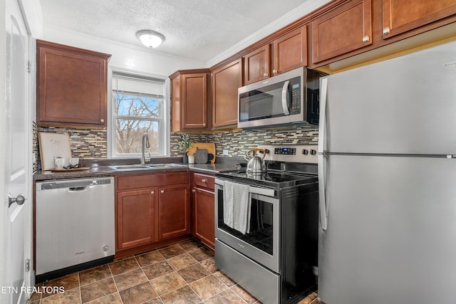 kitchen featuring stainless steel appliances, dark countertops, tasteful backsplash, a sink, and a textured ceiling