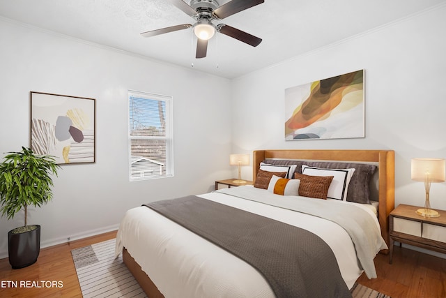 bedroom with ornamental molding, wood finished floors, a ceiling fan, and baseboards