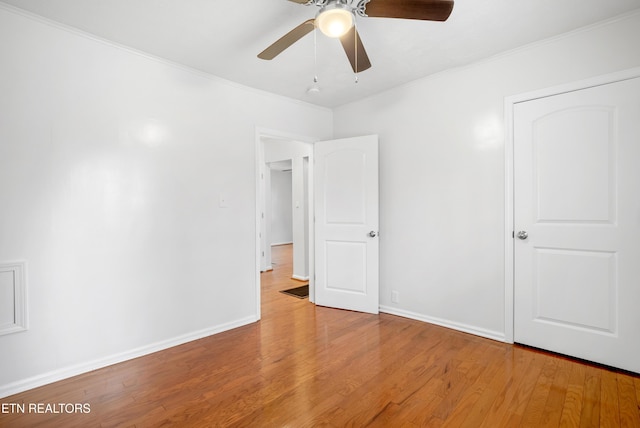 unfurnished bedroom with baseboards, ornamental molding, and wood finished floors