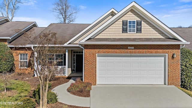 view of front of property with a porch, concrete driveway, brick siding, and a garage