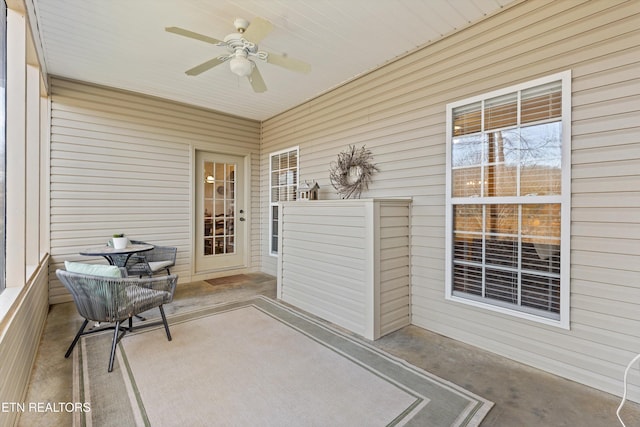 unfurnished sunroom featuring ceiling fan