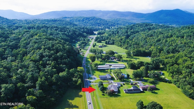 birds eye view of property featuring a wooded view and a mountain view