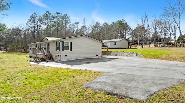 view of property exterior featuring metal roof, a lawn, driveway, and stairs