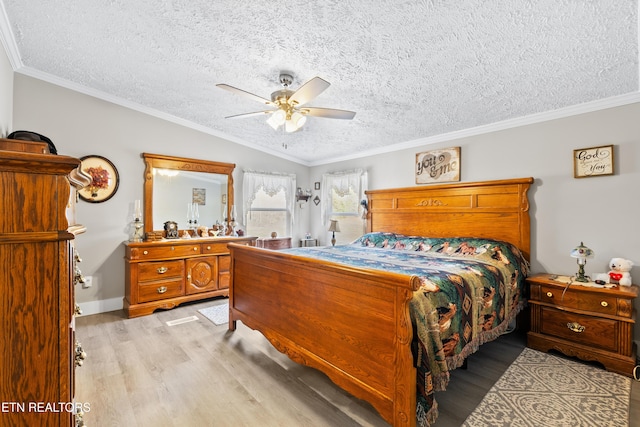 bedroom featuring light wood-type flooring, ornamental molding, vaulted ceiling, and a ceiling fan