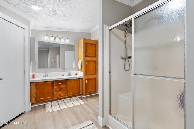 full bathroom with ornamental molding, a stall shower, and a sink