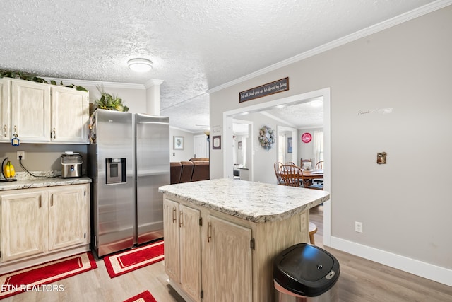 kitchen featuring light brown cabinets, light countertops, stainless steel fridge, and light wood-style flooring