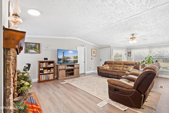 living area with a textured ceiling, ornamental molding, vaulted ceiling, and wood finished floors