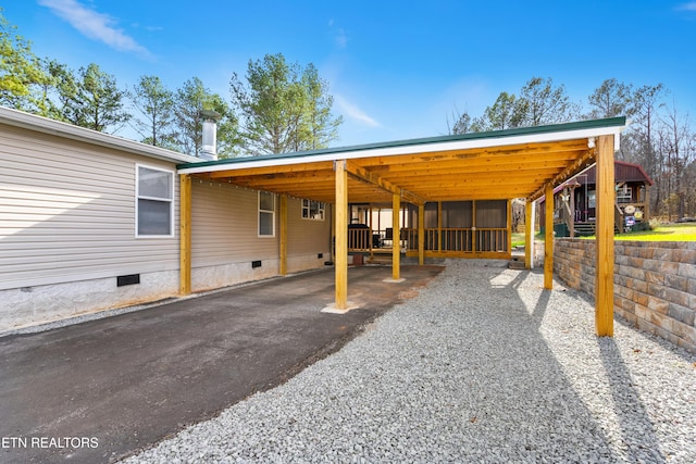 view of car parking with an attached carport and gravel driveway