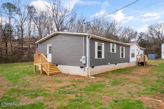 view of home's exterior with crawl space and a yard