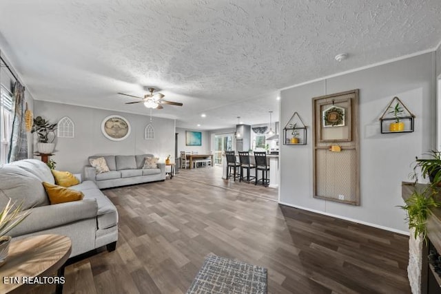 living room with ceiling fan, a textured ceiling, and wood finished floors