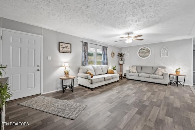 living room with a textured ceiling, wood finished floors, and a ceiling fan